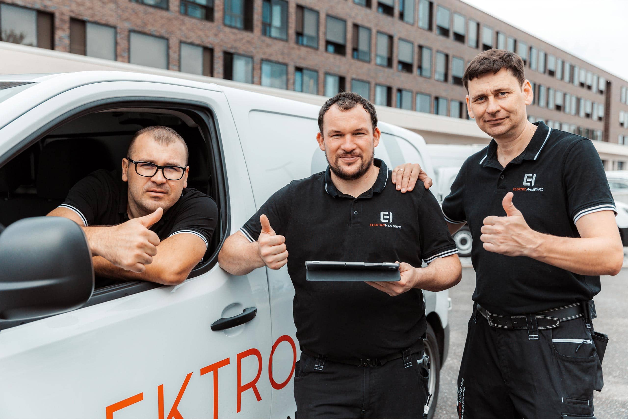 Mitarbeiter elektrohamburg daumen hoch zwei stehen einer im auto aus dem offene fenster foto von ©jonas radtke